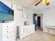 This bedroom features a ceiling fan, white dressers, light gray walls and carpet, and decorative shelving at 14529 Falling Tree Ct, Orlando, FL 32837