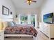 Bedroom with sliding glass doors to pool has neutral walls and carpet, ceiling fan, and white dressers at 14529 Falling Tree Ct, Orlando, FL 32837
