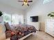 Bright bedroom boasts a ceiling fan, neutral walls and carpet, and sliding glass doors to the patio at 14529 Falling Tree Ct, Orlando, FL 32837