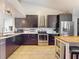 Modern kitchen with dark cabinetry, stainless steel appliances, tile flooring, and a functional island at 14529 Falling Tree Ct, Orlando, FL 32837