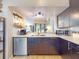 Stylish kitchen with stainless steel appliances, dark cabinetry, and a pass-through window to the adjacent dining area at 14529 Falling Tree Ct, Orlando, FL 32837