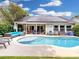 Backyard pool is surrounded by patio seating, lush landscaping, and a roof with solar panels at 14529 Falling Tree Ct, Orlando, FL 32837