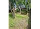 Backyard features green grass, mature trees, a wooden swing, and a view of the home at 1524 Crawford Dr, Apopka, FL 32703