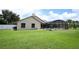 Green backyard with a screened-in pool and spa, perfect for outdoor enjoyment at 1546 Royal Cir, Apopka, FL 32703