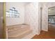Bathroom featuring a tub, glass enclosed shower, and natural light from a glass block window at 1546 Royal Cir, Apopka, FL 32703
