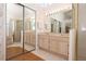 Bathroom with a double sink vanity, large mirror, glass enclosed shower, and walk-in closet at 1546 Royal Cir, Apopka, FL 32703