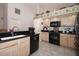Well-lit kitchen features light cabinetry, black appliances, black countertops and tiled floor at 1546 Royal Cir, Apopka, FL 32703