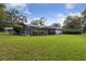 Wide shot of large backyard featuring a screened-in pool and lush green lawn at 1795 Markham Glen Cir, Longwood, FL 32779