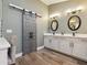 Modern bathroom featuring a double sink vanity, elegant lighting, and a unique barn door for privacy and style at 1795 Markham Glen Cir, Longwood, FL 32779