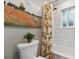 Cozy bathroom featuring a shower with a fun, decorative curtain, a toilet, and a vibrant landscape art piece at 1795 Markham Glen Cir, Longwood, FL 32779