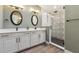 Elegant bathroom featuring double sinks, a decorative-tile walk-in shower, and modern fixtures at 1795 Markham Glen Cir, Longwood, FL 32779