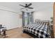 Well-lit bedroom with a black and white checkered bedspread, ceiling fan, wood floors, and large window at 1795 Markham Glen Cir, Longwood, FL 32779