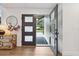 Welcoming entryway with a modern door, wood floors, decorative mirror and natural light at 1795 Markham Glen Cir, Longwood, FL 32779