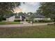 Inviting exterior with striking black and white design, mature trees, and a well-kept lawn at 1795 Markham Glen Cir, Longwood, FL 32779