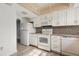 Well-lit kitchen with white appliances, wood flooring, and a tiled backsplash at 2250 S Palmetto Ave # I-11, Daytona Beach, FL 32119