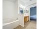 Bathroom featuring a large bathtub, wood-look flooring, and neutral-colored walls at 2353 Kingscrest Cir, Apopka, FL 32712