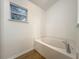 Bathroom featuring a large bathtub, wood-look flooring, and a window at 2353 Kingscrest Cir, Apopka, FL 32712