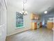 Bright dining area with backyard views and kitchen featuring light wood cabinets and stainless steel appliances at 2353 Kingscrest Cir, Apopka, FL 32712