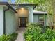 Close-up of the home's entrance with a dark front door and lush, green landscaping at 2353 Kingscrest Cir, Apopka, FL 32712