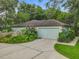 Spacious garage with a wide driveway surrounded by mature trees and landscaping at 2353 Kingscrest Cir, Apopka, FL 32712