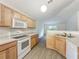 Well-lit kitchen with wood cabinets, modern appliances, and an open layout leading to the living area at 2353 Kingscrest Cir, Apopka, FL 32712