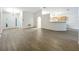 Open-concept living room with modern wood floors that lead to the kitchen and entryway at 2353 Kingscrest Cir, Apopka, FL 32712