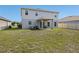 Exterior view of the backyard with a covered patio, lush lawn, and serene outdoor space at 253 Fiddlewood Ct, Davenport, FL 33837