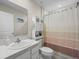 Bathroom with a single sink, cabinet, and a shower with a patterned curtain, creating a neat space at 253 Fiddlewood Ct, Davenport, FL 33837