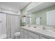 Bathroom featuring double sinks, a large mirror, and a shower with white tiling, creating a clean and functional space at 253 Fiddlewood Ct, Davenport, FL 33837