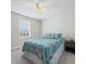 Bedroom with a patterned blue and yellow bedspread, side table, and a window for natural light at 253 Fiddlewood Ct, Davenport, FL 33837
