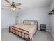 Bedroom with a black bed frame, ceiling fan and a wooden shelf, offering a cozy and comfortable space at 253 Fiddlewood Ct, Davenport, FL 33837