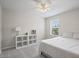 Bright bedroom with a white bed, shelving unit, and a window that provides ample natural light at 253 Fiddlewood Ct, Davenport, FL 33837