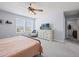Bright bedroom featuring a ceiling fan, cozy chair, and a dresser with a TV, creating a relaxing space at 253 Fiddlewood Ct, Davenport, FL 33837