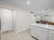 The kitchen shows white cabinets, marble countertops, and an entranceway to a living area at 253 Fiddlewood Ct, Davenport, FL 33837