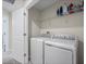 Bright laundry room includes a washer, a dryer, and plenty of storage space on shelving above at 253 Fiddlewood Ct, Davenport, FL 33837