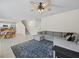 Spacious living room features a modern ceiling fan, staircase, and gray sectional sofa on an area rug at 253 Fiddlewood Ct, Davenport, FL 33837