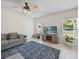 Cozy living room with tiled floors, a gray couch, and a flat-screen TV at 253 Fiddlewood Ct, Davenport, FL 33837