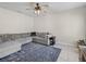 Spacious living room featuring a large gray sectional and patterned rug on tiled flooring at 253 Fiddlewood Ct, Davenport, FL 33837