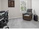 An office area features a desk, shelves, reading chair, natural light and neutral tones at 253 Fiddlewood Ct, Davenport, FL 33837