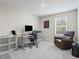 An office space features a desk, chair, shelves, reading chair and natural light from the window at 253 Fiddlewood Ct, Davenport, FL 33837