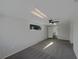 Carpeted bedroom with a window, ceiling fan and neutral paint, leading to additional rooms at 2575 King Ave, Auburndale, FL 33823
