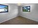 Bedroom features neutral carpet, black-framed windows and updated lighting at 2575 King Ave, Auburndale, FL 33823