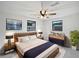 Comfortable main bedroom featuring two windows, a ceiling fan, and neutral decor at 2575 King Ave, Auburndale, FL 33823
