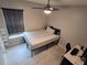 A tidy bedroom featuring neutral walls, faux-wood flooring, a ceiling fan, and a window at 3028 Lakes Crest Ave, St Cloud, FL 34772