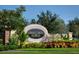 Welcome to Gramercy Farms sign surrounded by lush landscaping and greenery, creating an inviting entrance at 3028 Lakes Crest Ave, St Cloud, FL 34772