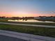 Scenic view of a tranquil pond at sunset, reflecting the colorful sky and surrounding homes at 3028 Lakes Crest Ave, St Cloud, FL 34772