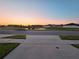 Scenic view of a tranquil pond at sunset, reflecting the colorful sky and surrounding homes at 3028 Lakes Crest Ave, St Cloud, FL 34772