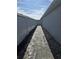 Paver walkway between home and fence with black mulch and blue sky at 3028 Lakes Crest Ave, St Cloud, FL 34772