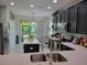 Modern kitchen with dark cabinetry, stainless steel appliances, and a view of the backyard at 3458 Sagebrush St, Harmony, FL 34773