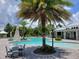 Community pool with a palm tree island, lounge chairs, and seating areas for relaxing by the water at 3458 Sagebrush St, Harmony, FL 34773